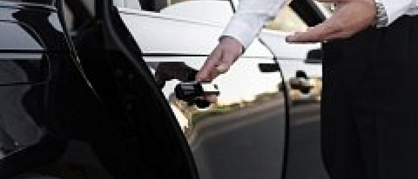Member of staff opening a car door, valet service