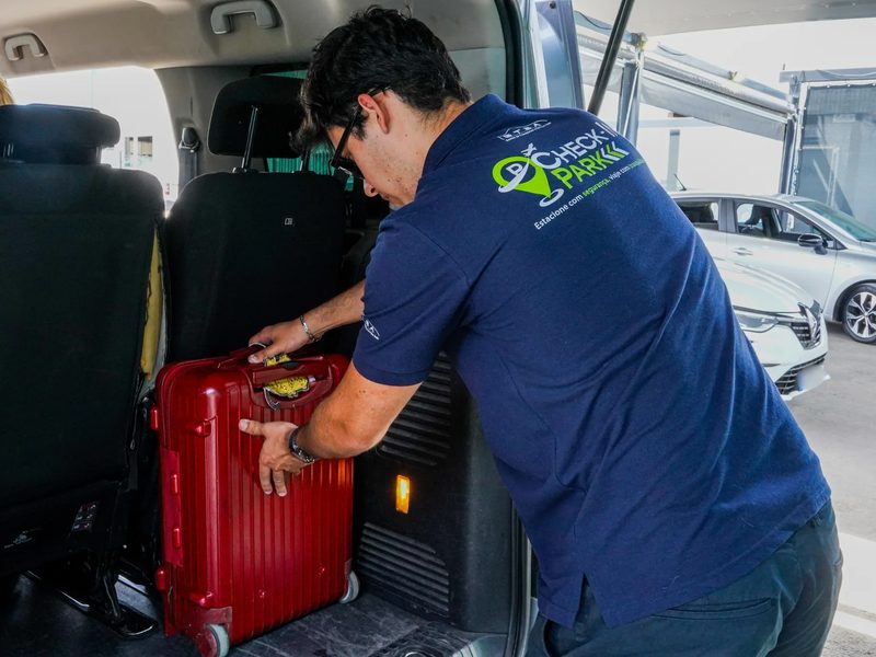 Colaborador do Check-in Park a carregar a bagagem na carrinha do transfer