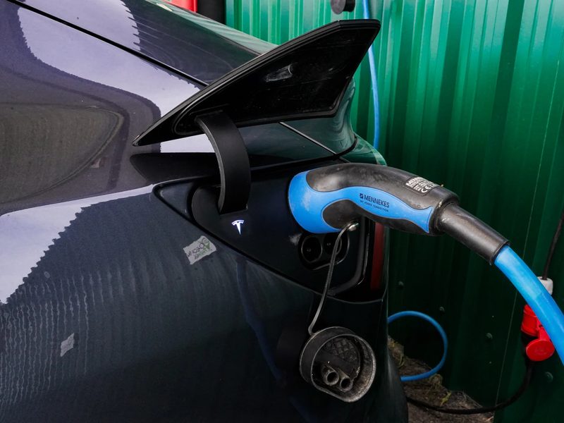 Cargador conectado a un coche el&eacute;ctrico en el aparcamiento de Check-in Park