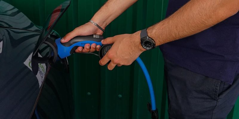 Check-in Park team member plugging in an electric car charger