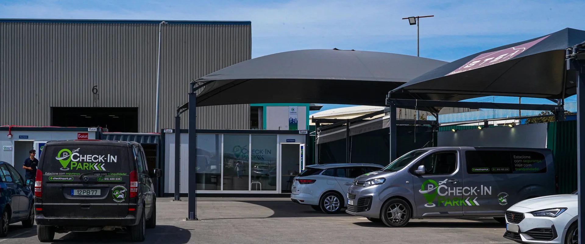 Parque de estacionamento privado do Check-in Park, com as carrinhas do transfer