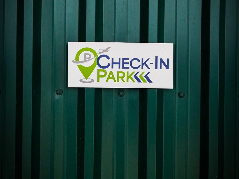 Check-in Park sign on the car park fence